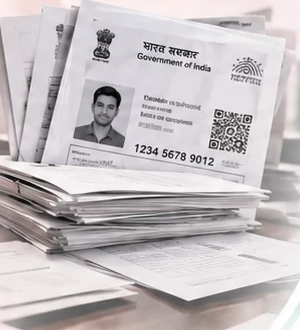 A pile of photocopied Aadhaar cards and papers